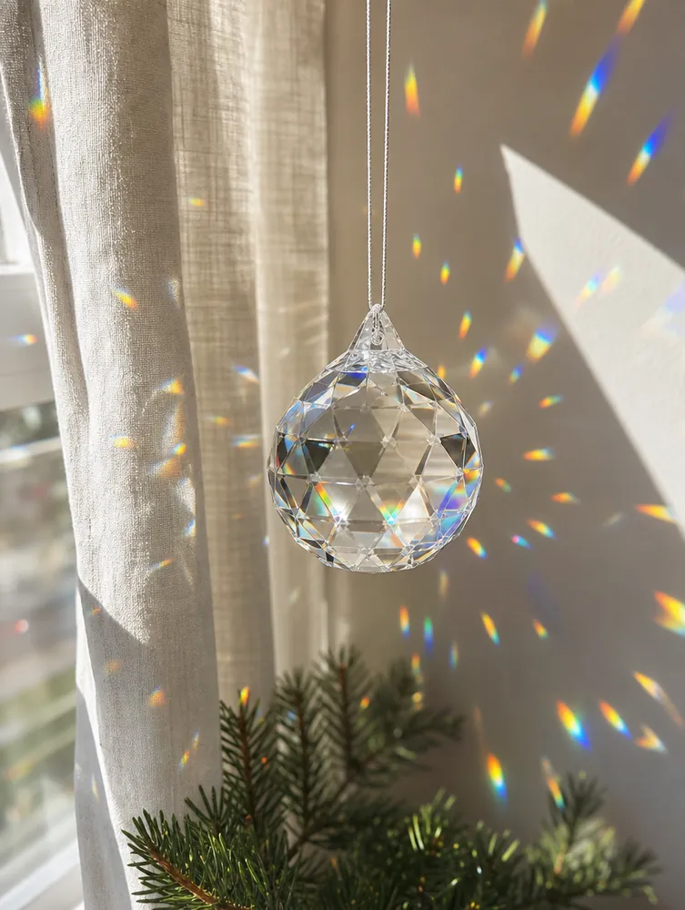 Boule de cristal facettée projetant des arcs-en-ciel